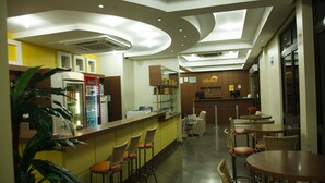 A restaurant with a bar area, seating, and a counter.