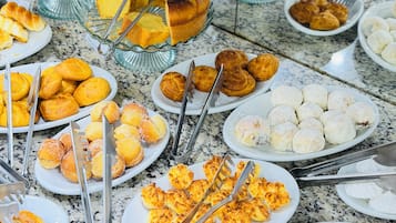 Un bufé con diversas opciones de panadería, incluyendo pasteles, bollos y pan.