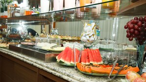 A buffet with various food items including watermelon, papaya, and grapes.