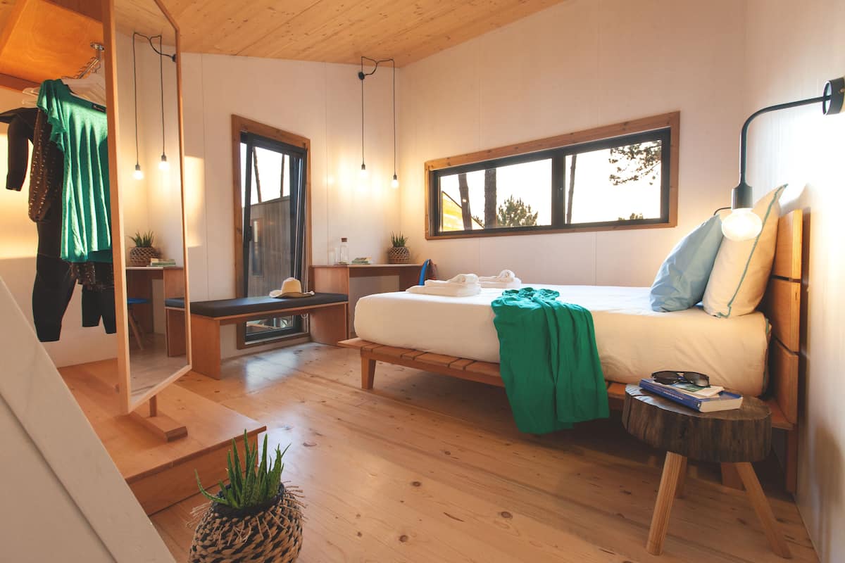 A bedroom with a bed, bedside table, and a window.