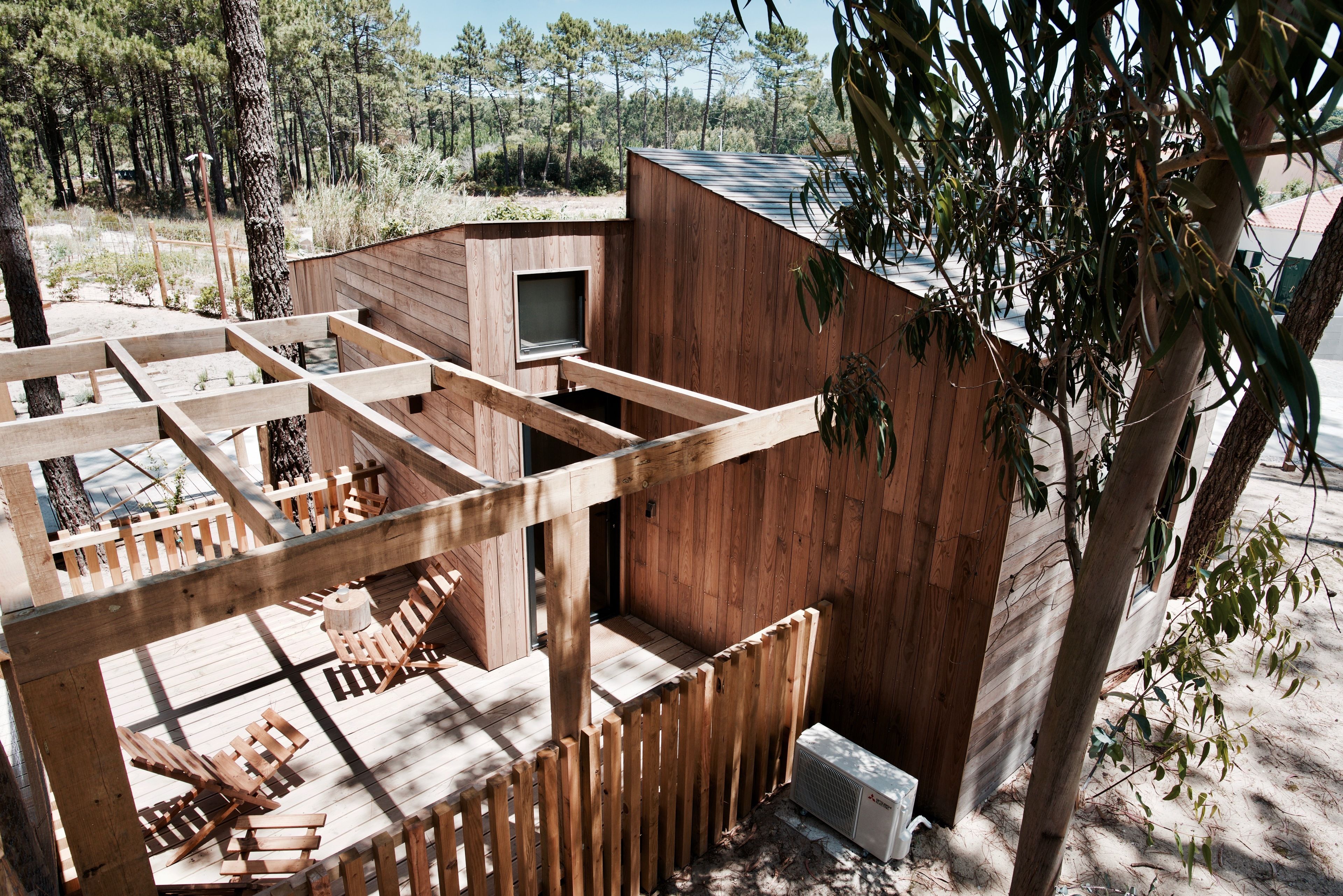 A wooden cabin with a deck and outdoor seating area.