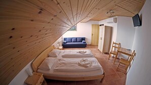 Un dormitorio con techo de madera, una cama, un sofá azul y una mesa de madera.