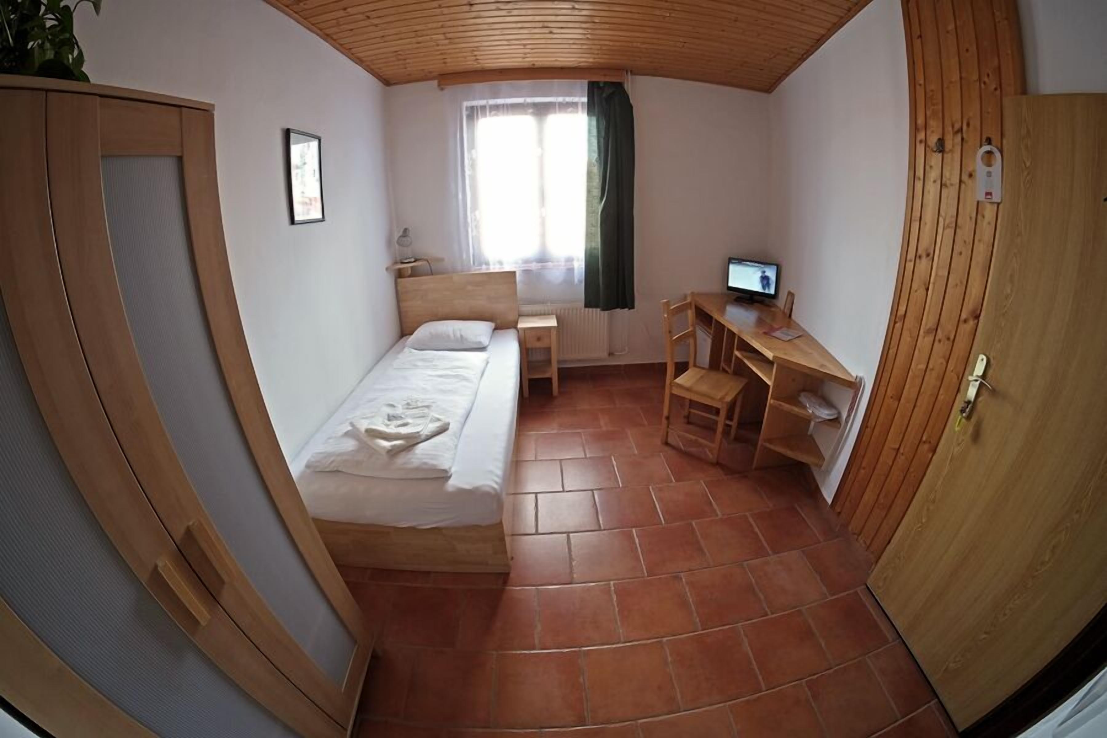 A compact room with a bed, a desk, and a chair.