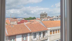 A view of a cityscape with a prominent church and residential buildings with red-tiled roofs. - Burgus Tribute & Design Hotel (Braga)