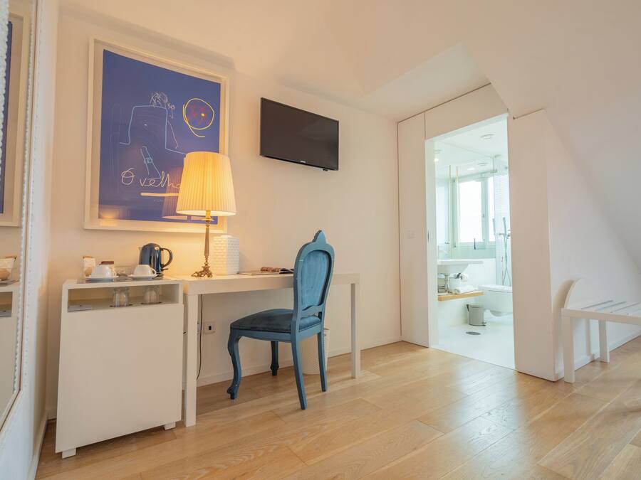Une chambre moderne équipée d’un bureau, d’une chaise et d’un téléviseur fixé au mur.