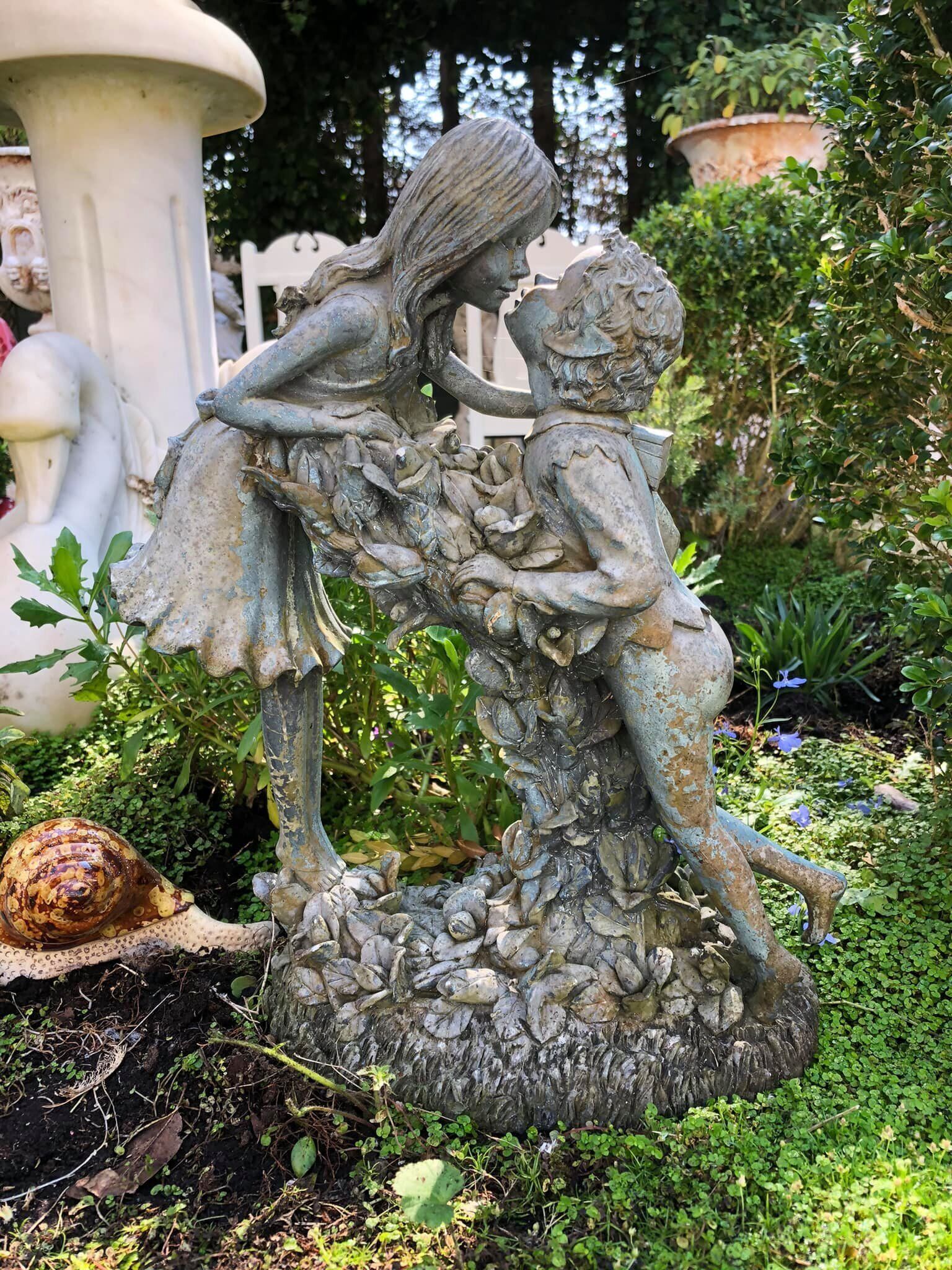A garden statue of a woman and child.