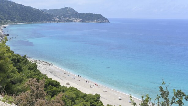 A coastal beach with clear turquoise waters, a sandy shore, and a mountainous backdrop. - Nerina Studios (Lefkada)