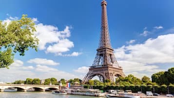 The Eiffel Tower with a river and a bridge in the foreground.