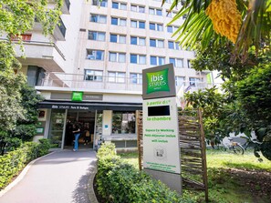 An entrance to ibis Styles hotel with a sign indicating amenities like co-working space, small kitchenette, and wifi. - ibis Styles Paris 16 Boulogne (Boulogne-Billancourt)