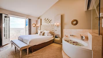 Une chambre d’hôtel avec un grand lit, une baignoire, un bureau et une vue sur l’extérieur.