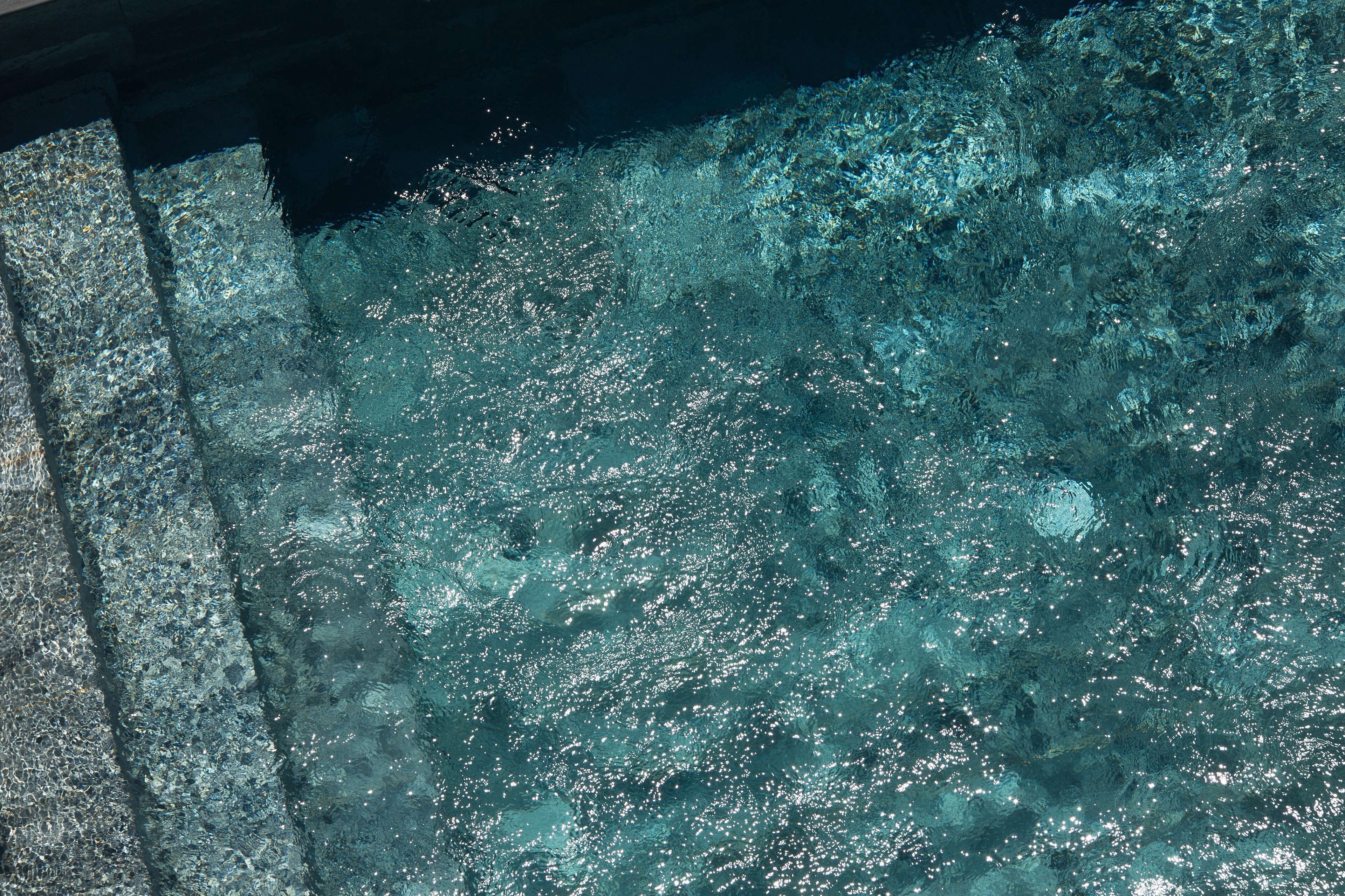 A pool with clear water and visible underwater rocks.