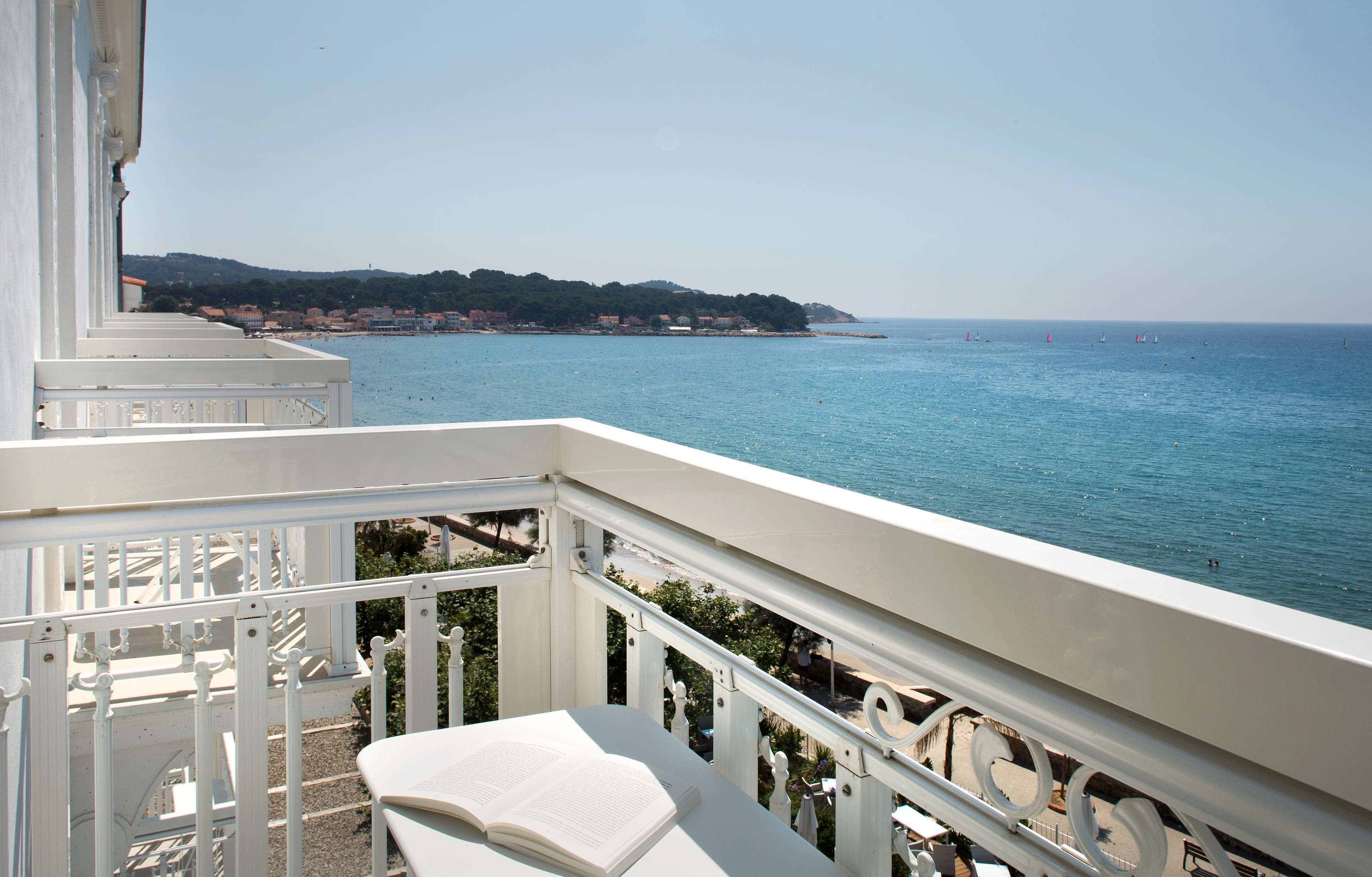 A balcony with a view of the sea and a distant coastline.