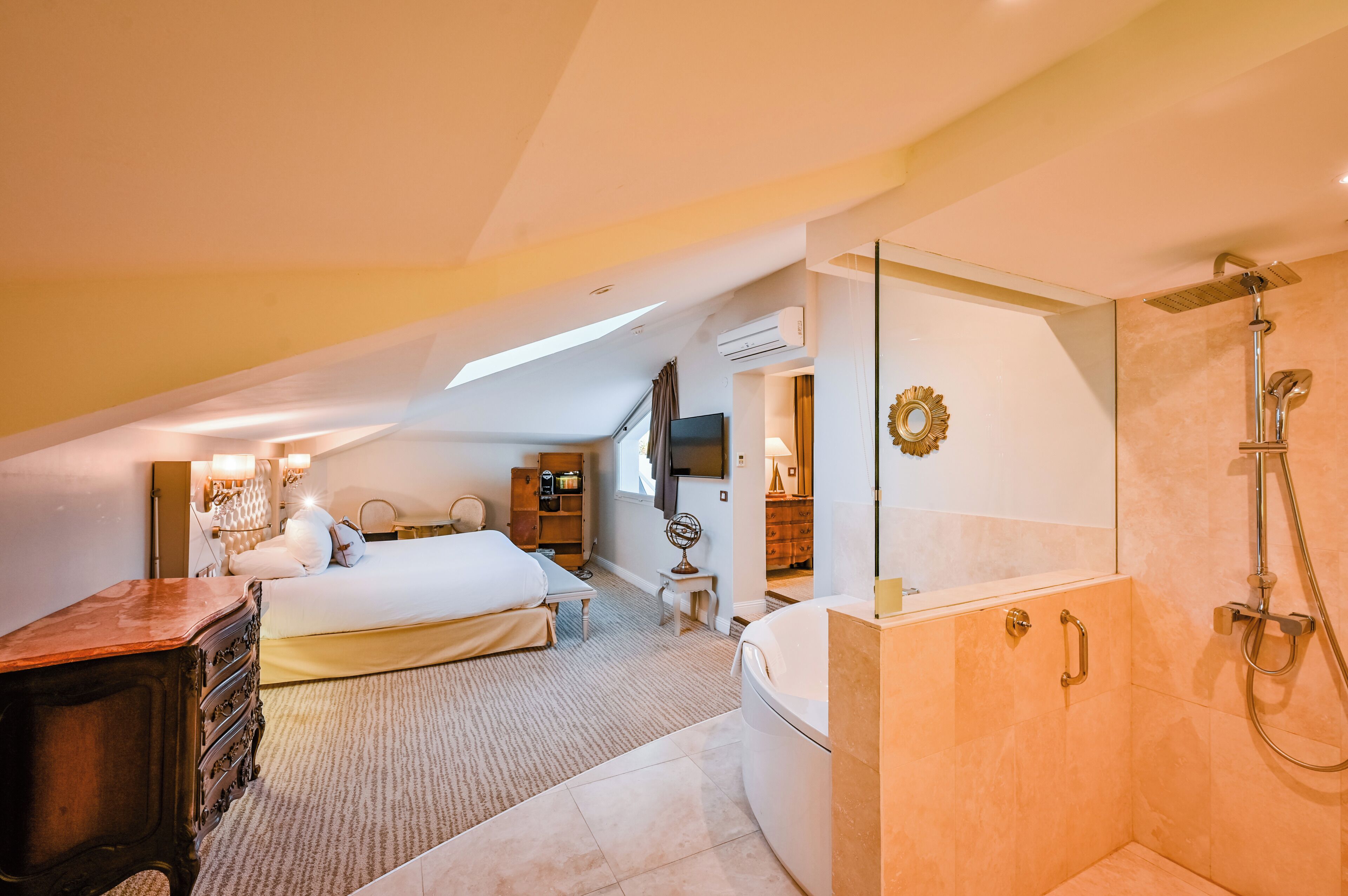 Ein Schlafzimmer mit Bett, Kommode, Schminktisch und Dusche.