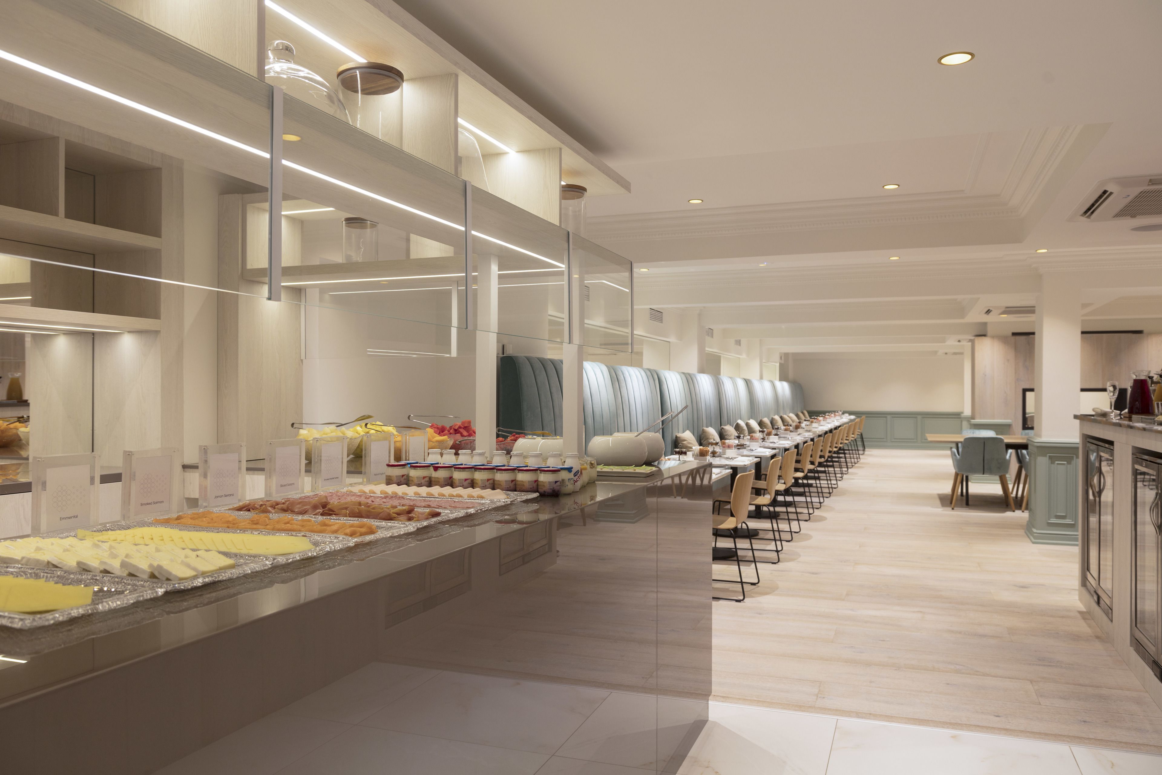 A buffet area with multiple serving stations and a long dining table with chairs.