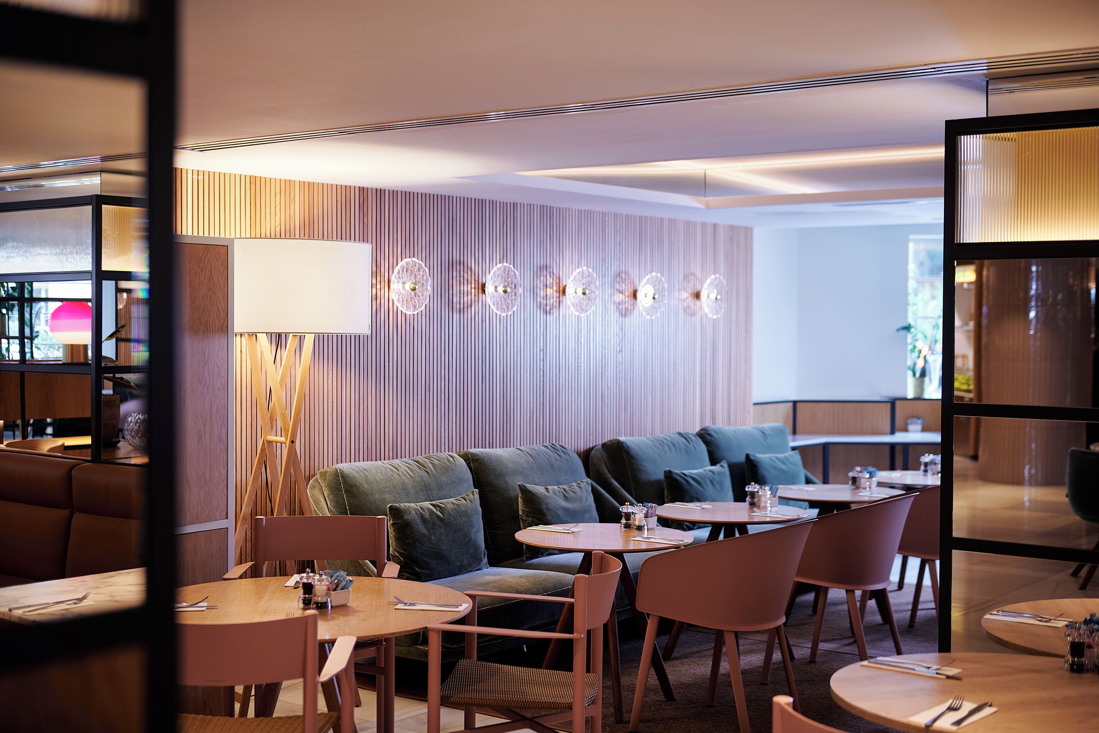A modern interior with a sofa, round tables, and chairs.