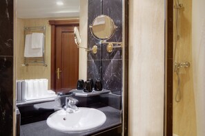 A bathroom with a white sink, a mirror, and a shower. - Melia White House Apartments (London)