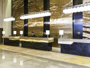 A reception desk with marble tops and modern lighting fixtures.