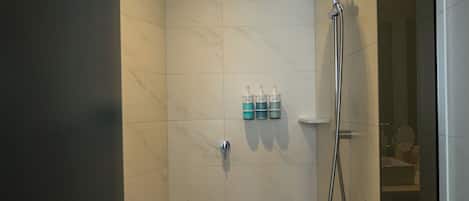 A modern shower with a handheld showerhead and a wall-mounted faucet.