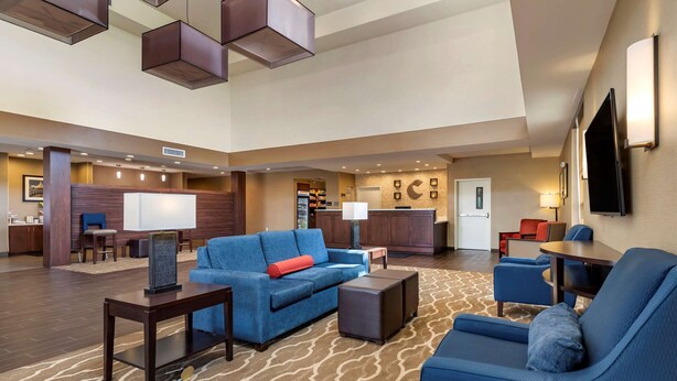 A spacious lobby with a blue sofa, a coffee table, and a patterned carpet. - Comfort Suites Kyle (Kyle)