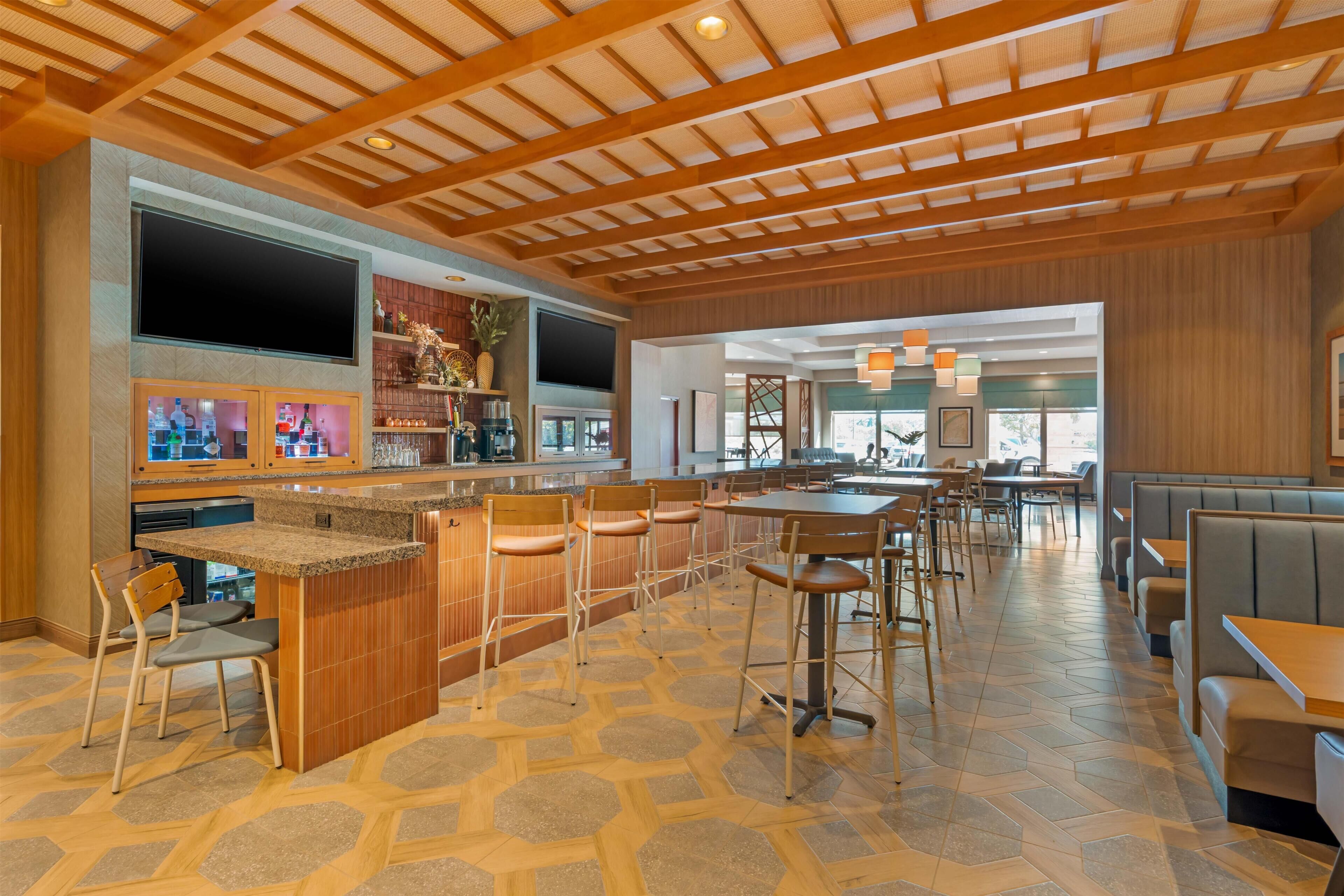 A spacious restaurant with a central island, bar area, and seating arrangements.