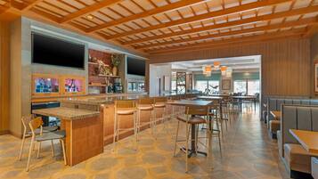 A spacious restaurant with a central island, bar area, and seating arrangements.