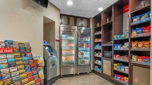 Un quiosco de autoservicio, dos vitrinas refrigeradas y estantes llenos de aperitivos y bebidas.