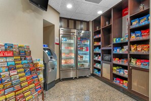 Un quiosco de autoservicio, dos vitrinas refrigeradas y estantes llenos de aperitivos y bebidas.
