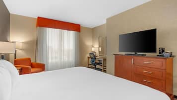 Une chambre d’hôtel avec un grand lit, un bureau avec une chaise, une télévision et une armoire.
