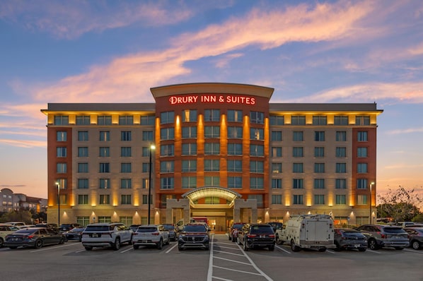 Un hotel Drury Inn & Suites con un estacionamiento lleno de coches.