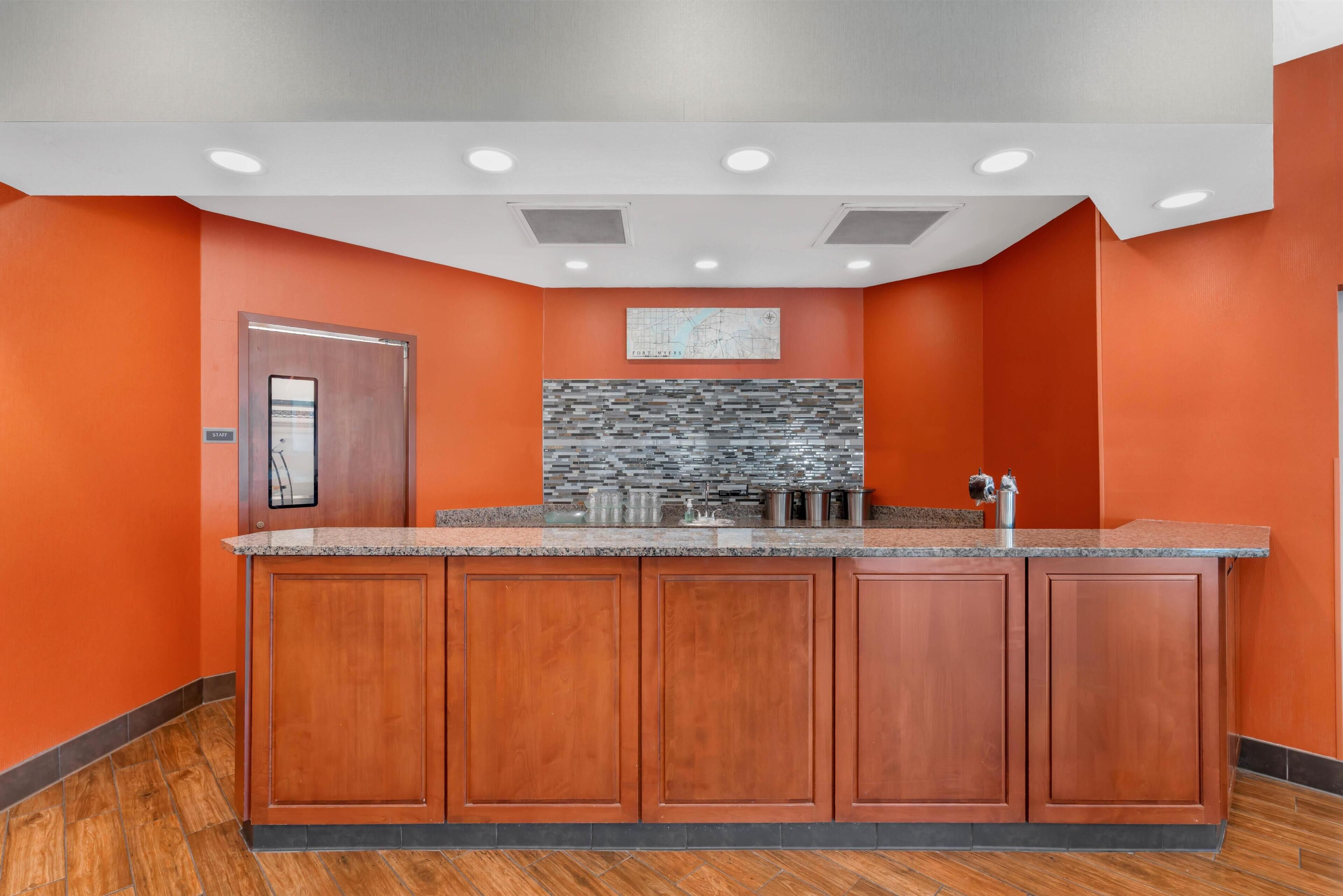 A modern kitchen with a wooden island, a backsplash, and a map on the wall.