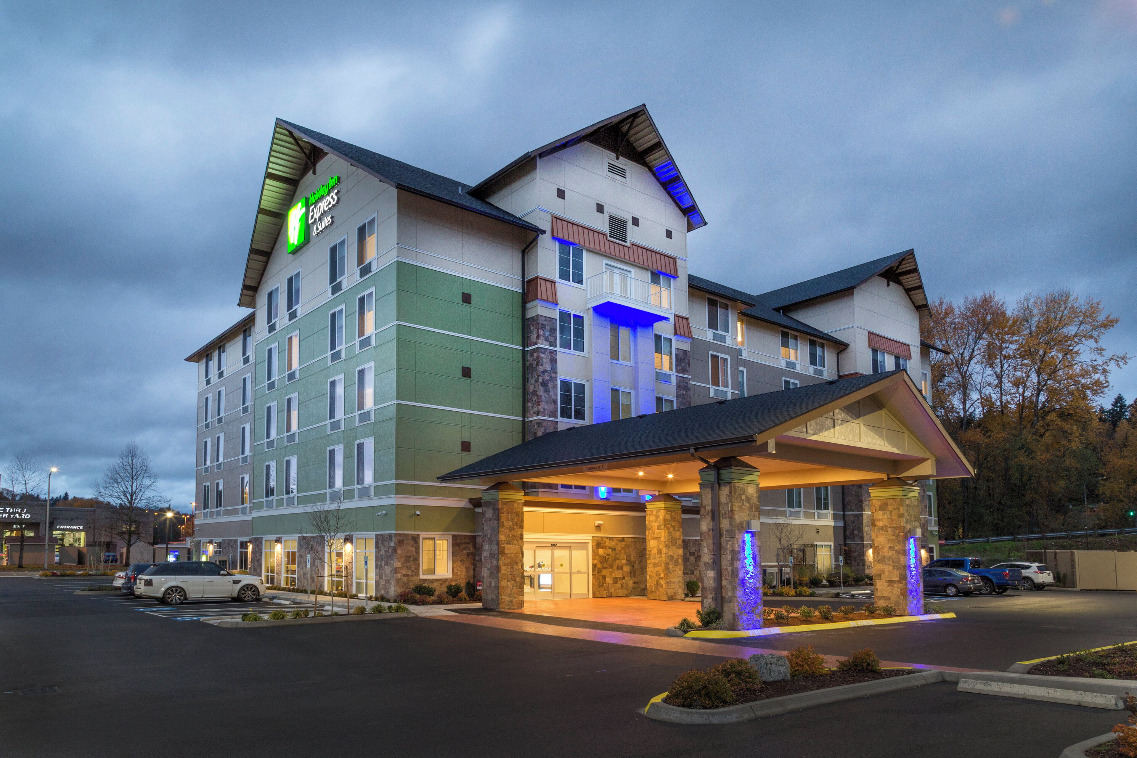 A multi-story hotel with a prominent entrance and a parking lot.