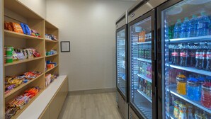 Un présentoir réfrigéré pour boissons, avec une variété de boissons, et une étagère à collations garnie d’un assortiment de produits.