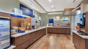 A modern breakfast area with a self-serve station, a bakery section, and a fruit and cereal display. - Holiday Inn Express Spring Hill by IHG (Spring Hill)