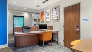 A hotel reception desk with a computer, printer, and a sign indicating mechanical/luggage storage. - Holiday Inn Express Spring Hill by IHG (Spring Hill)