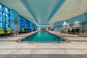 Una piscina con sillas amarillas y techo azul.