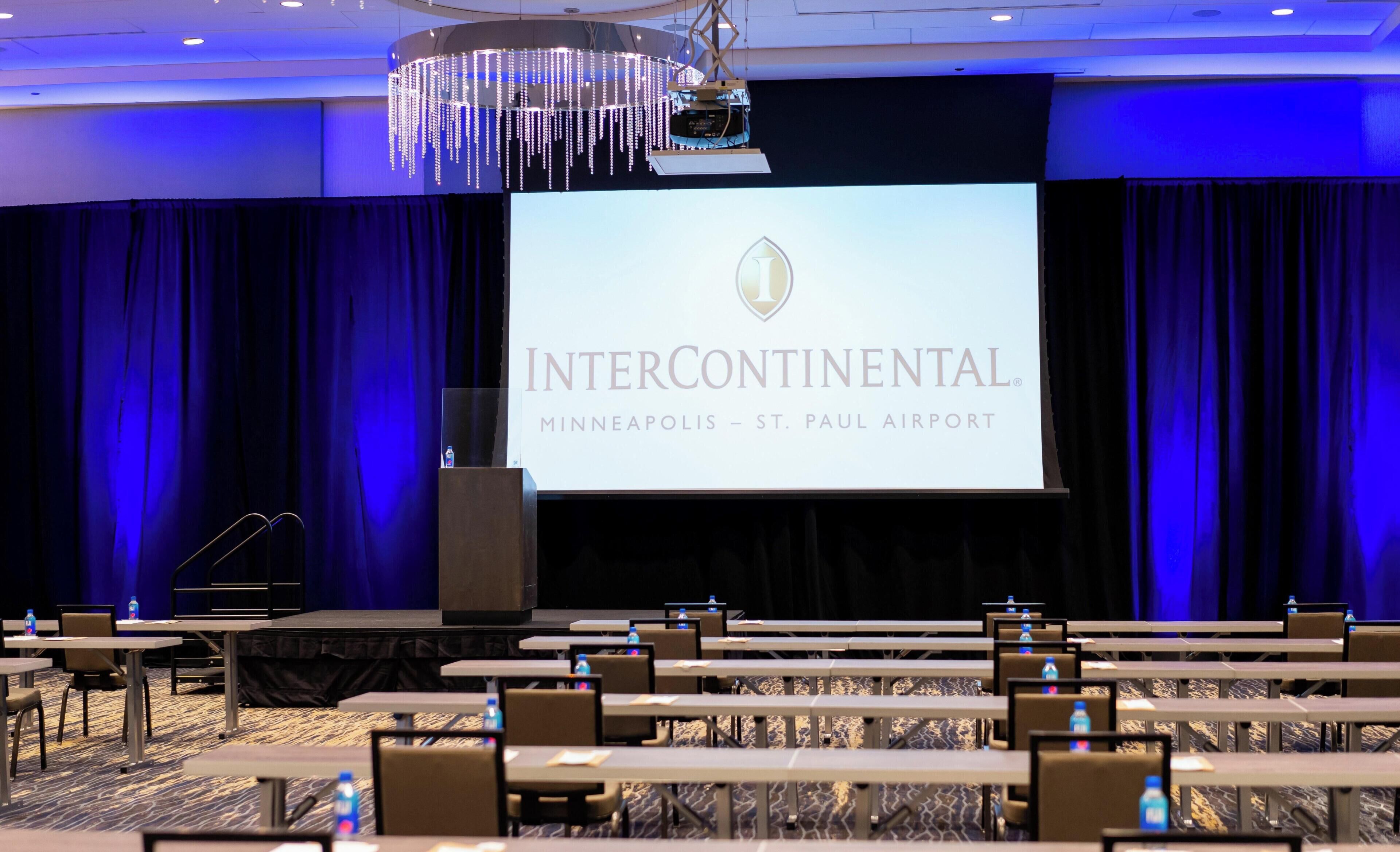 A conference room with a large screen displaying 'INTERCONTINENTAL MINNEAPOLIS - ST. PAUL AIRPORT'.