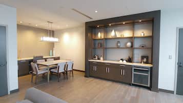 A modern kitchen with a dining area, wooden cabinets, and a built-in bookshelf.