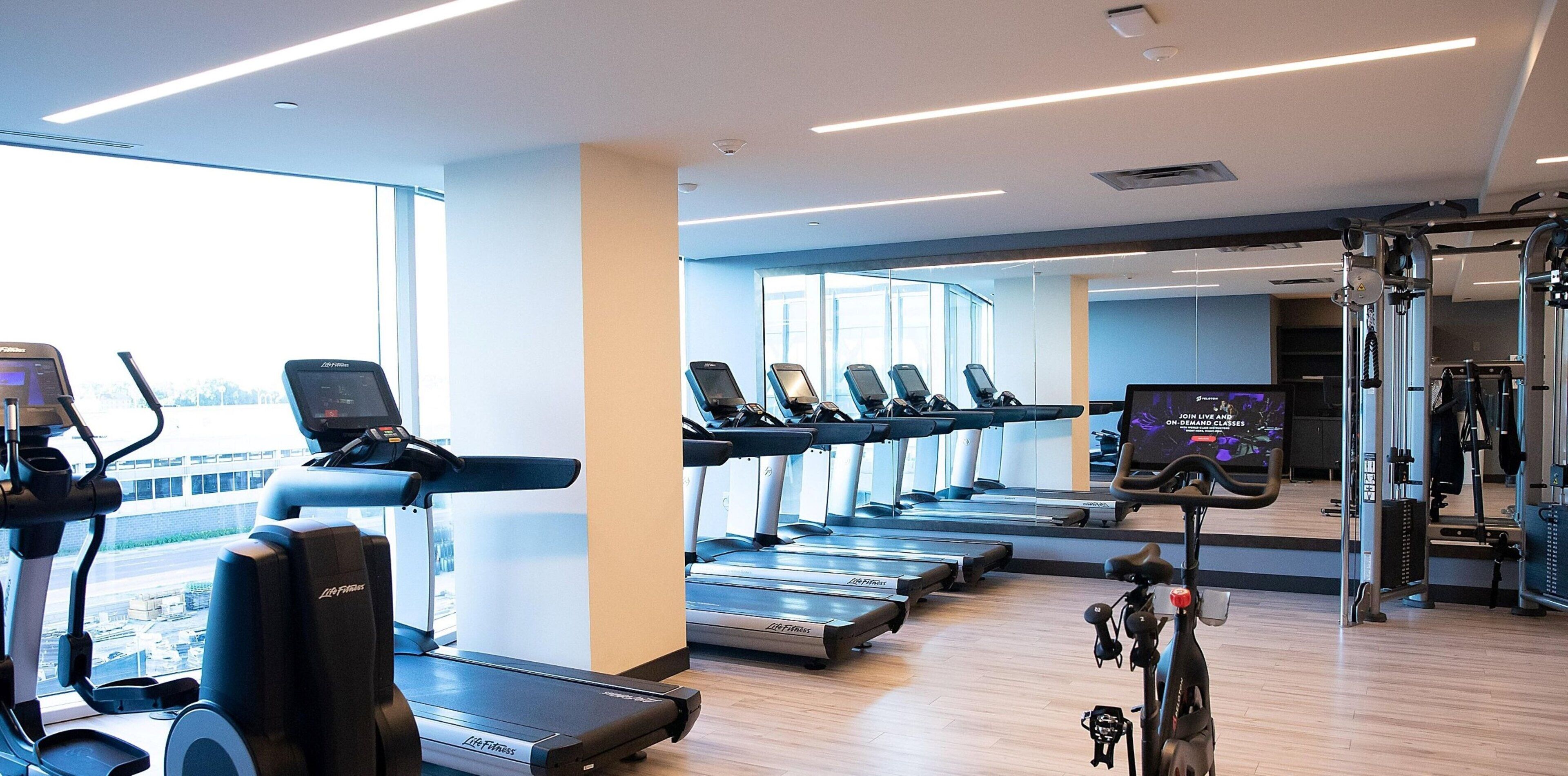 A gym with treadmills, exercise bikes, and weight machines.