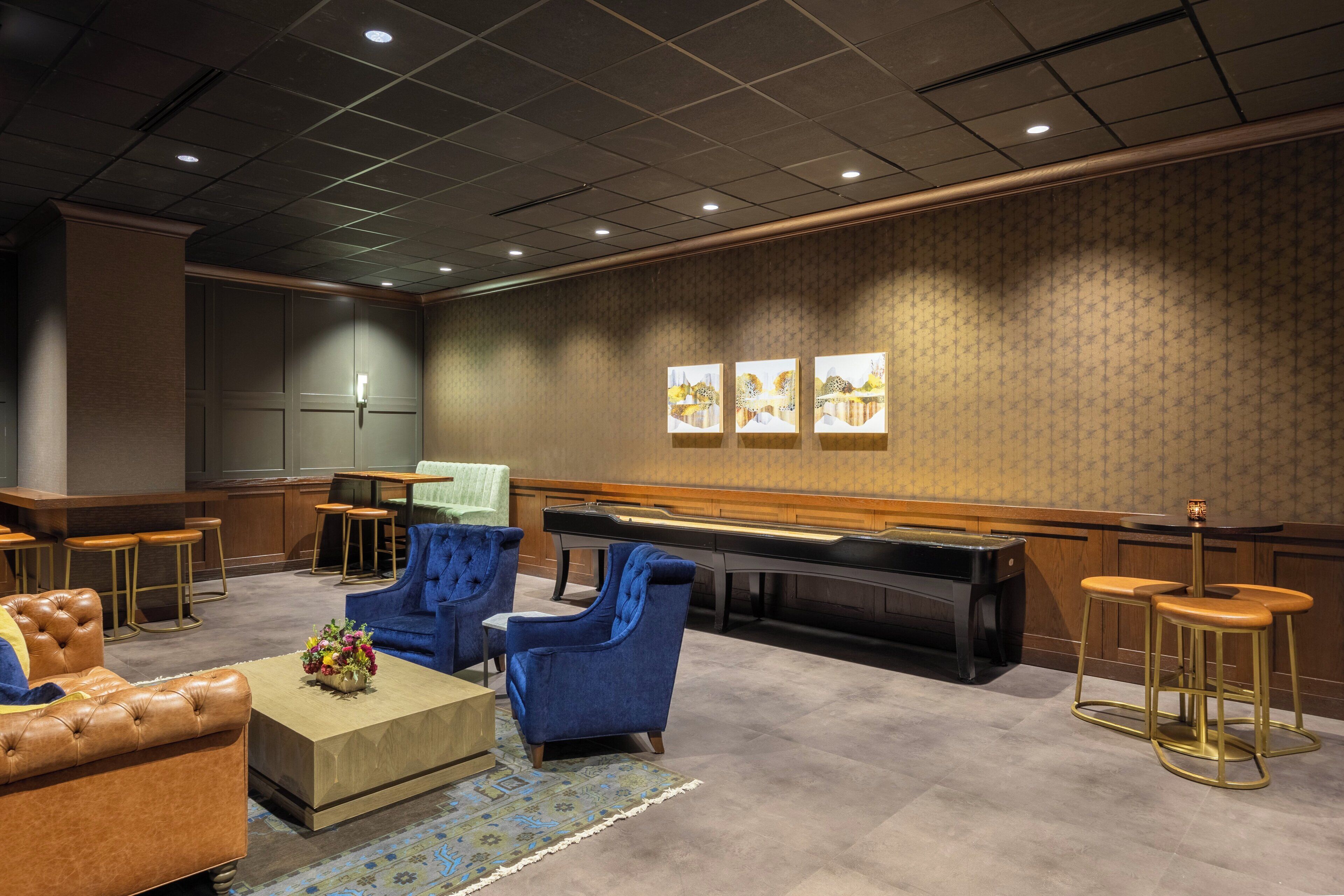 A lobby with a bar area, seating, and artwork on the wall.