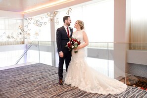 Una pareja en un balcón con un interior moderno, decoraciones geométricas en la pared y una alfombra estampada.