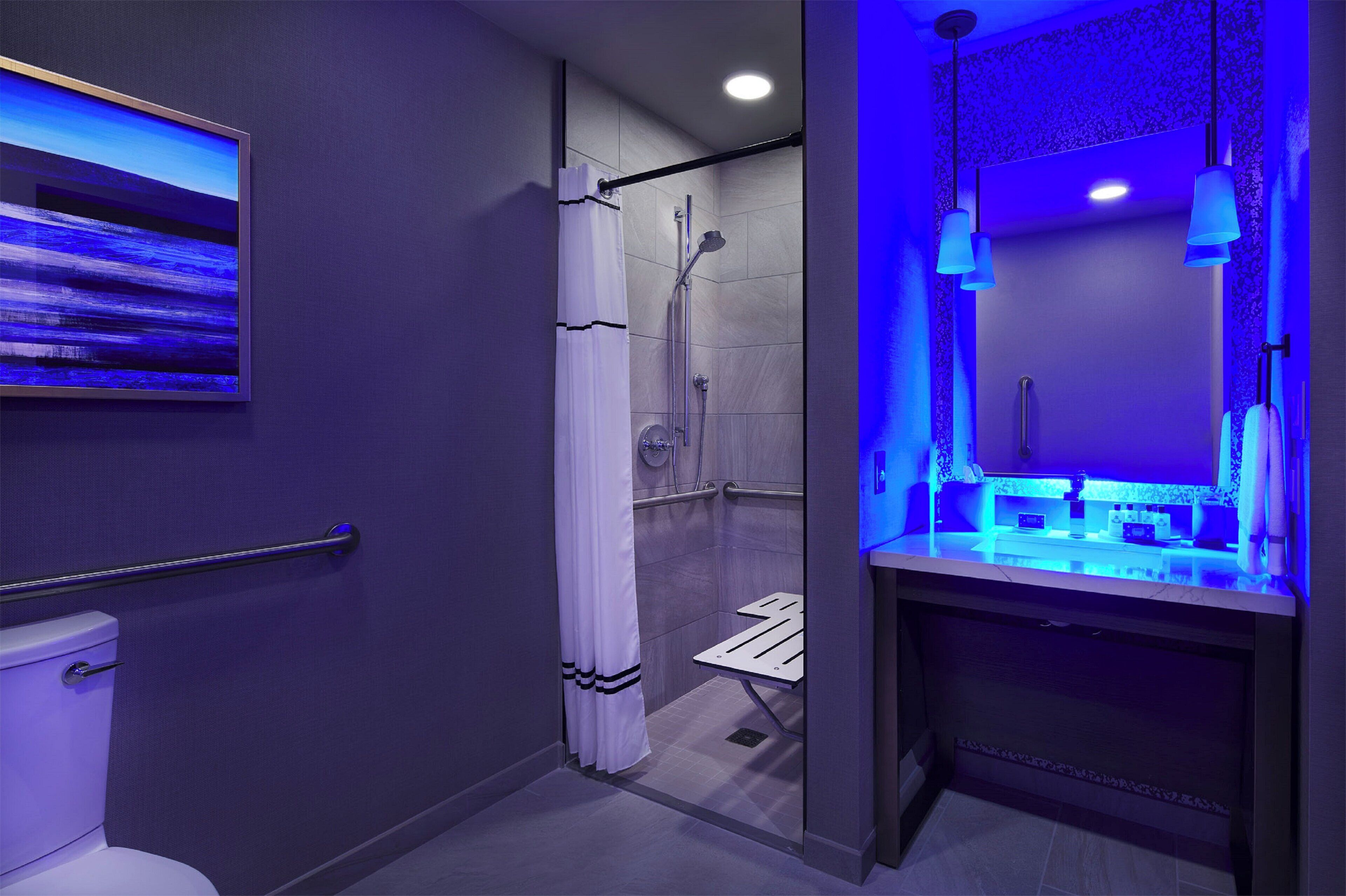A modern bathroom with a shower, toilet, and sink.