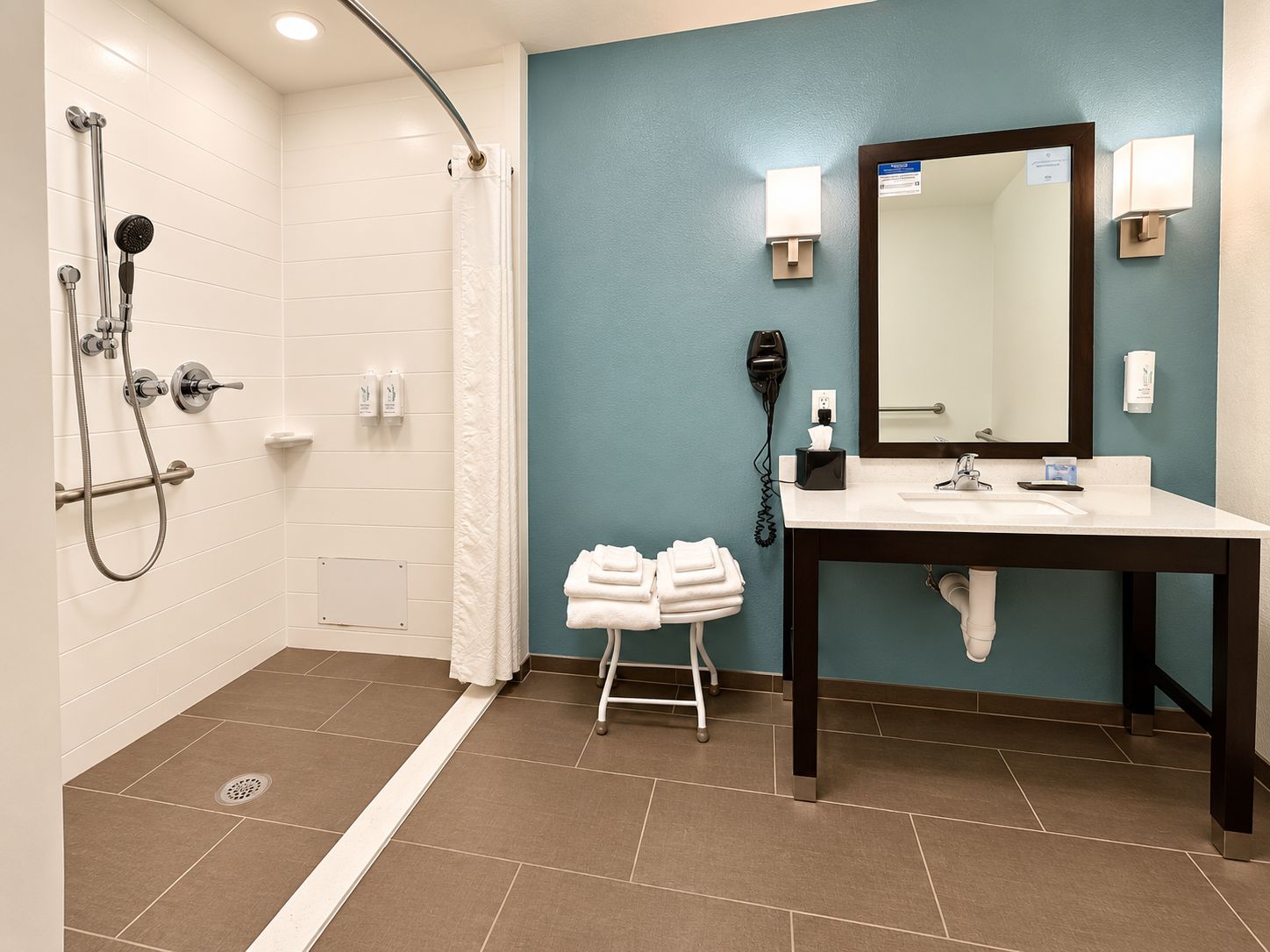 Un baño con ducha, lavamanos, espejo y toallero.