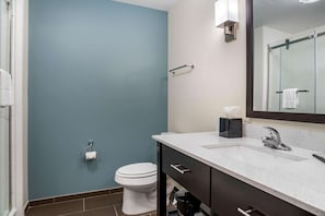 A bathroom with a white toilet, a sink with a mirror, and a towel rack. - Sleep Inn & Suites Houston Westchase - Little Saigon (Houston)