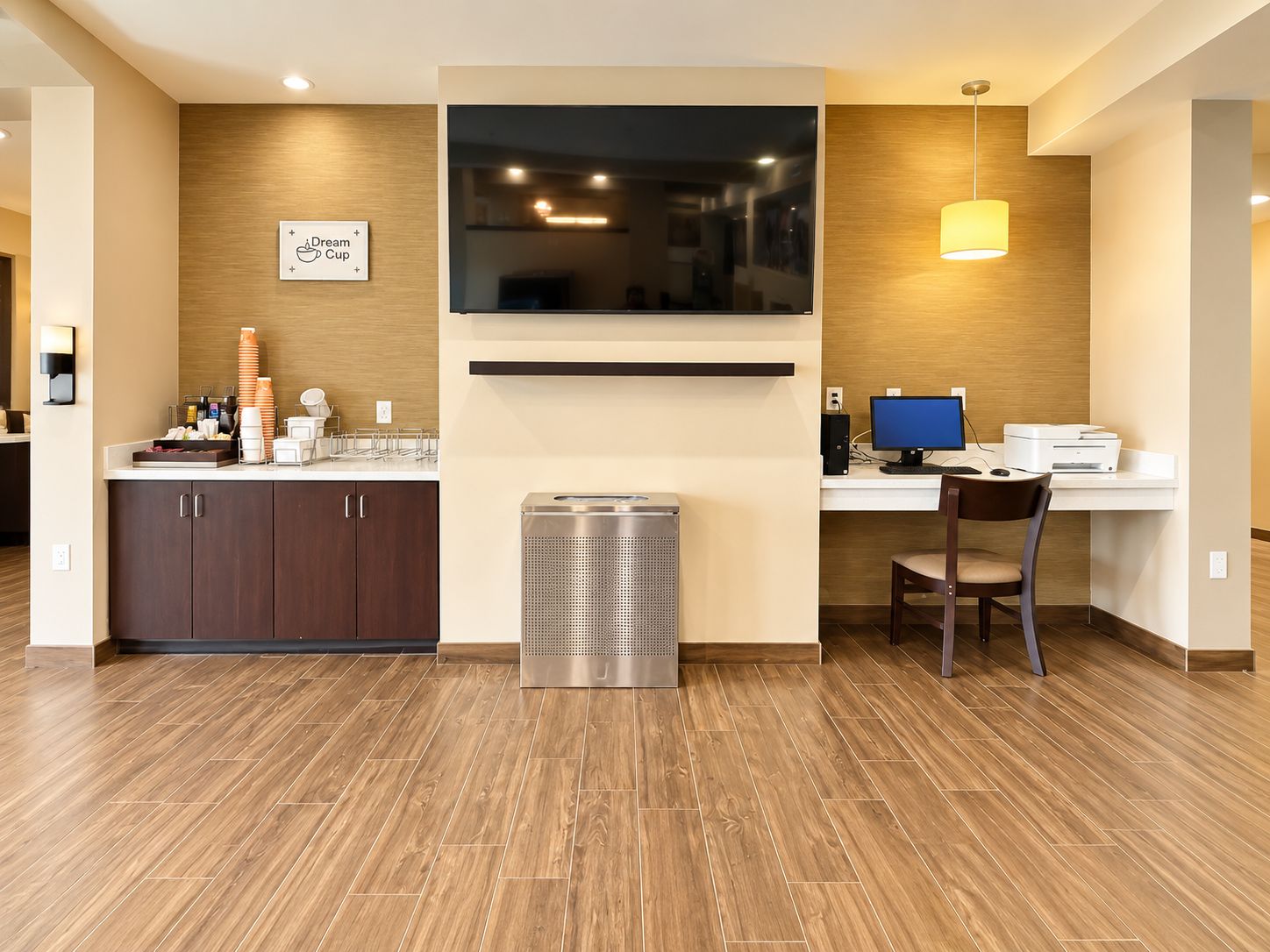 A modern kitchen with a built-in microwave, a coffee station, and a seating area with a table and chair.