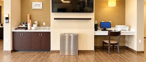 Una cocina moderna con microondas integrado, una estación de café y un área de estar con mesa y silla.