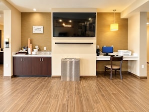 A modern kitchen with a built-in microwave, a coffee station, and a seating area with a table and chair. - Sleep Inn & Suites Houston Westchase - Little Saigon (Houston)