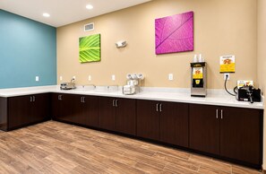 A modern kitchen with dark wooden cabinets, a white countertop, a coffee machine, and a waffle maker. - Sleep Inn & Suites Houston Westchase - Little Saigon (Houston)