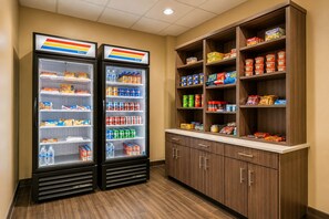 Two refrigerated beverage dispensers and a pantry stocked with snacks and beverages. - Sleep Inn & Suites Houston Westchase - Little Saigon (Houston)