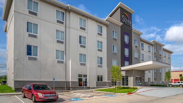 A multi-story hotel with a modern design, featuring a prominent entrance and a parking area. - Sleep Inn & Suites Houston Westchase - Little Saigon (Houston)