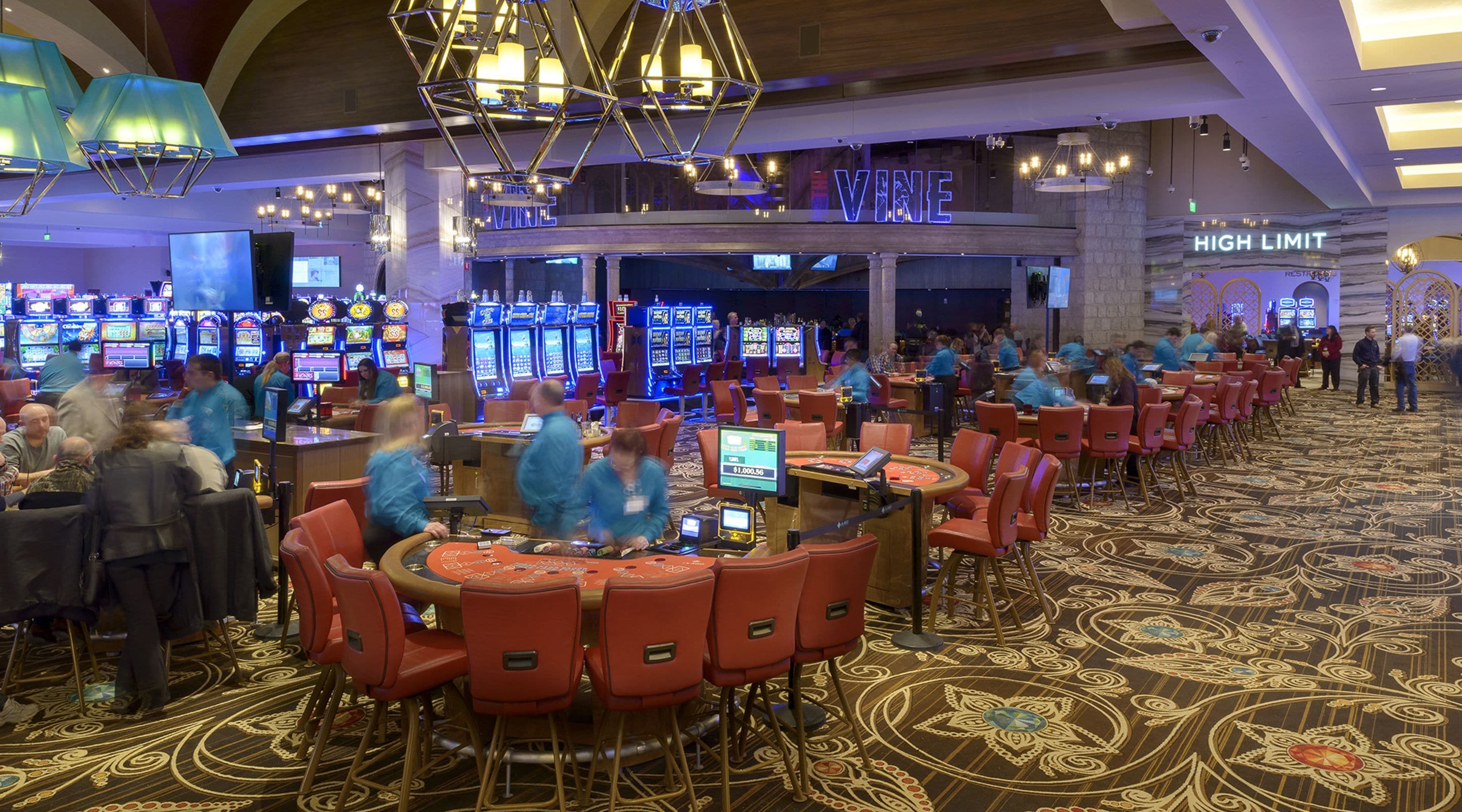 Un casino con varias mesas de juego y máquinas tragamonedas.